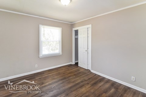 A room with a wooden floor and a white door.