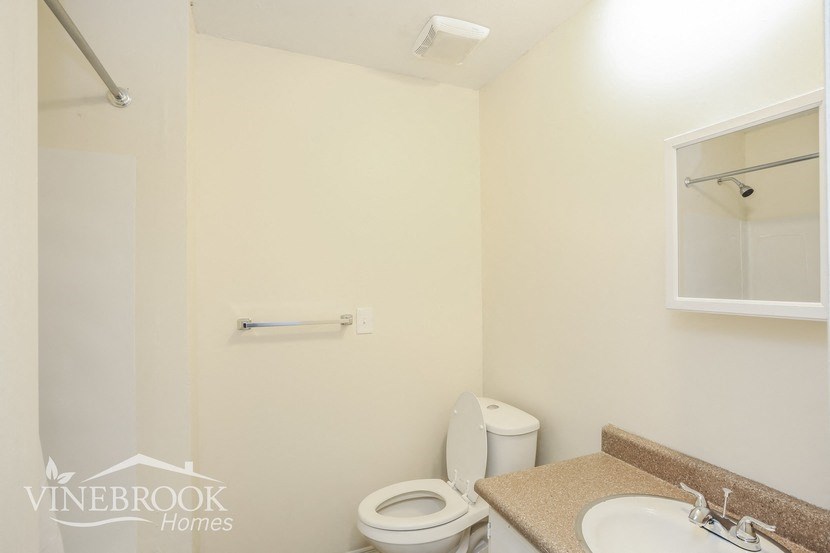 a bathroom with a toilet and a sink and a mirror