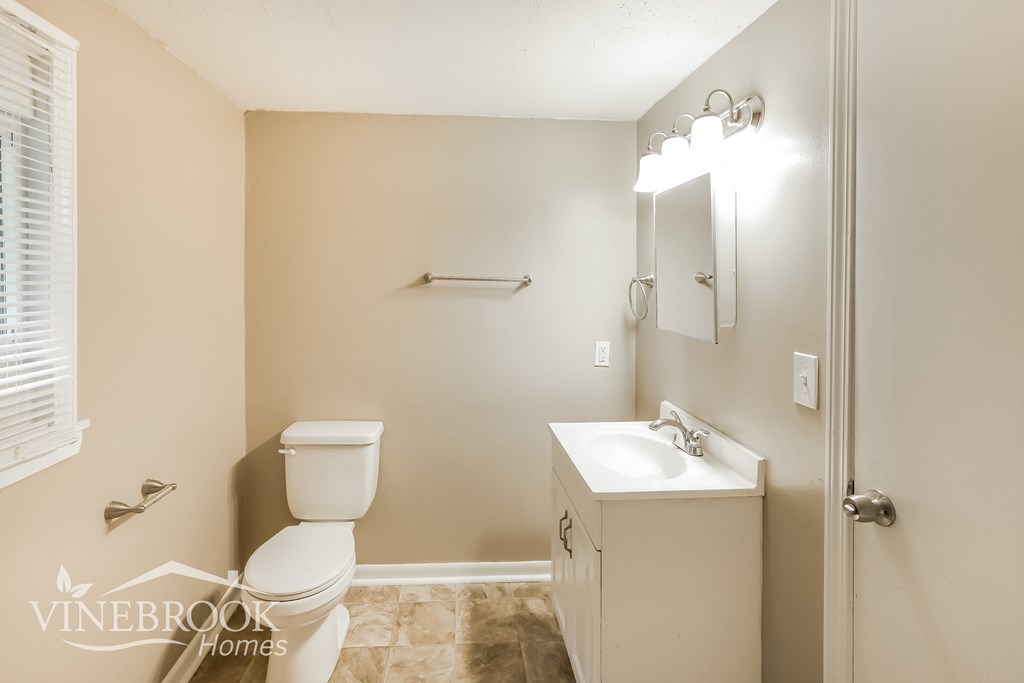 a bathroom with a toilet and a sink and a mirror
