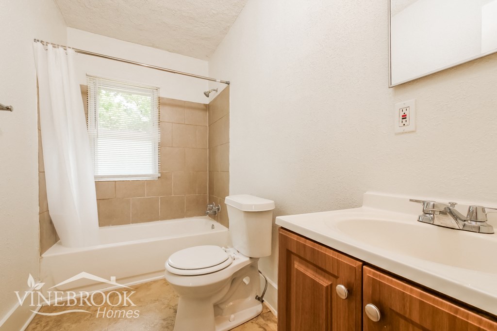 a bathroom with a toilet and a sink and a tub
