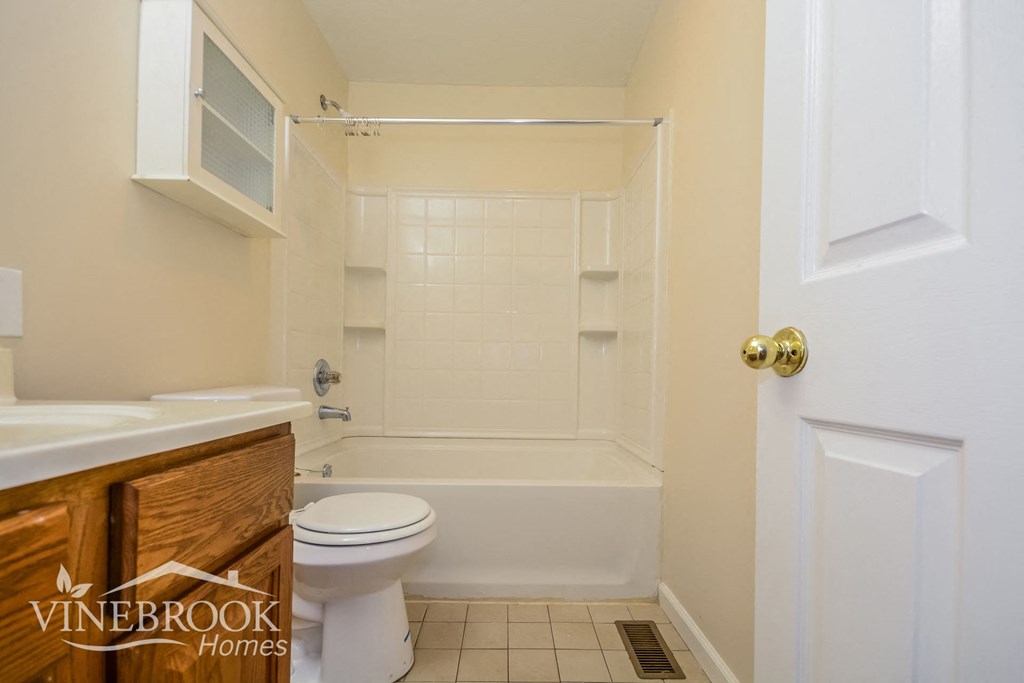 a bathroom with a toilet and a tub and a sink