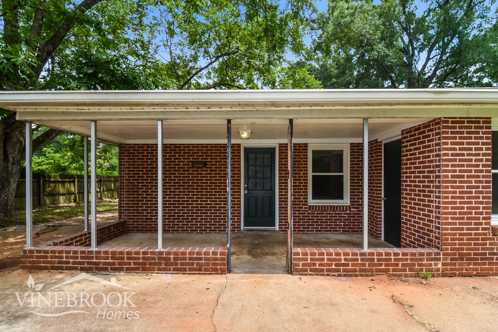 a small brick house with a porch and a blue door