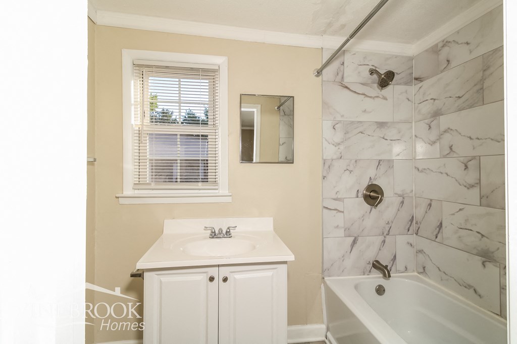 a bathroom with a sink and a tub and a shower