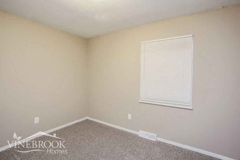 a small room with a window and a carpet