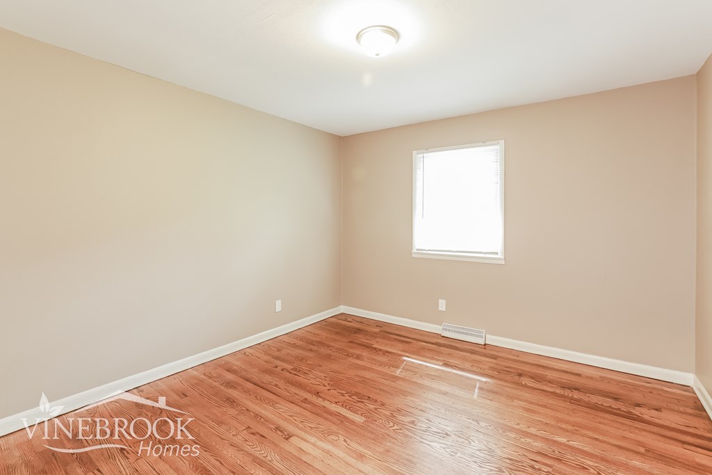 a living room with wood floors and a window