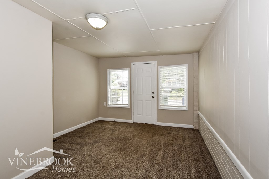 a bedroom with a carpeted floor and a white door