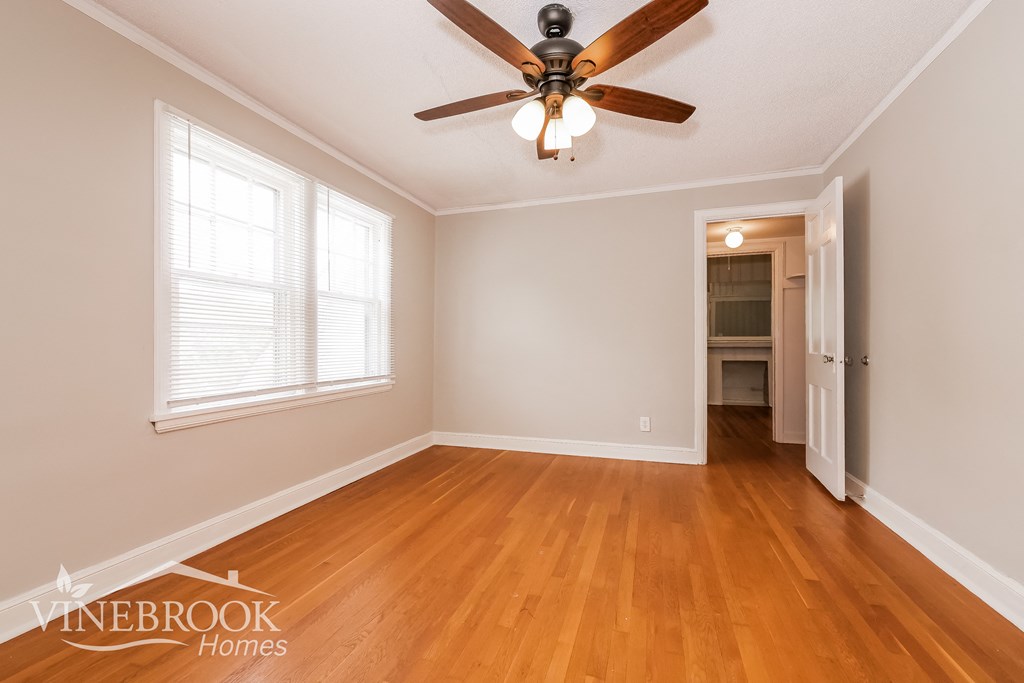 a living room with wood floors and a ceiling fan