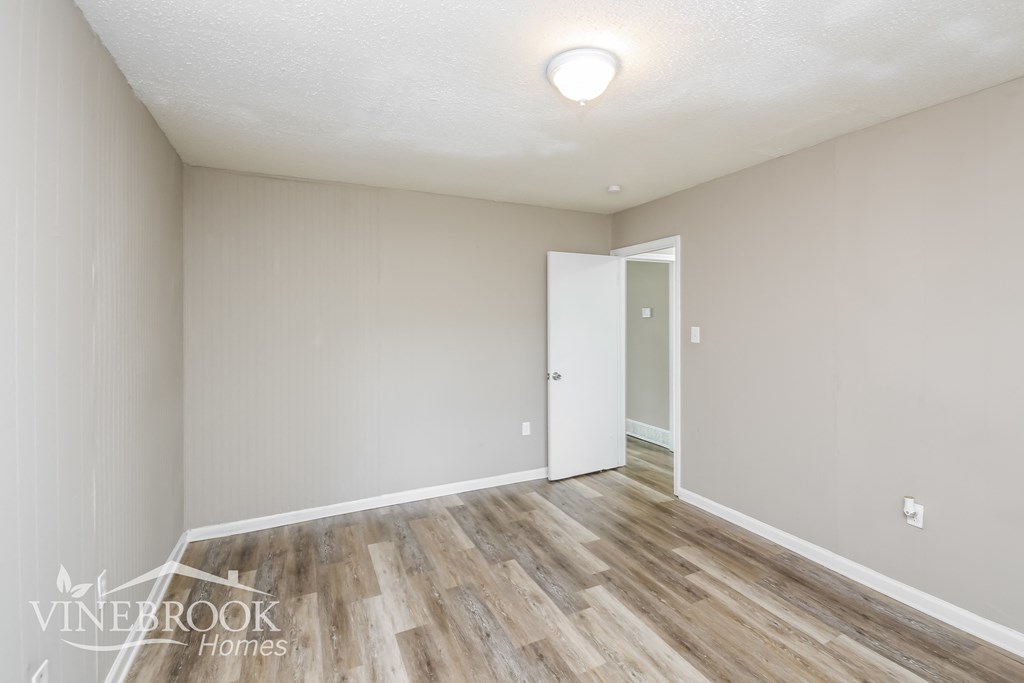 a renovated living room with wood flooring and white walls