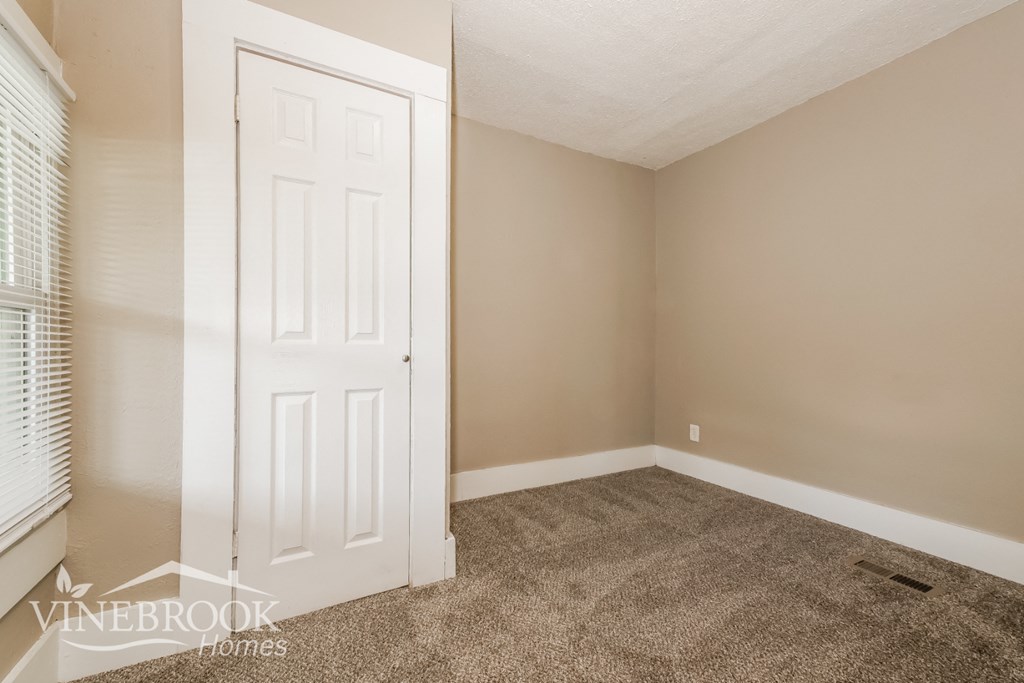 a bedroom with carpet and a white door