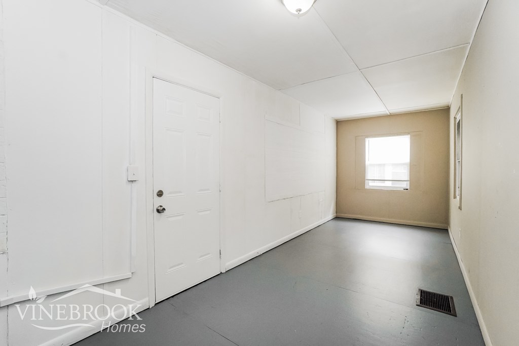 a white room with a white door and a window