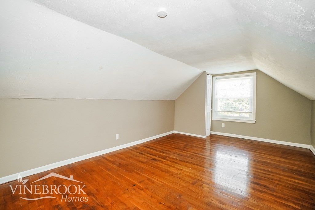 the living room of a home with wood floors and a window