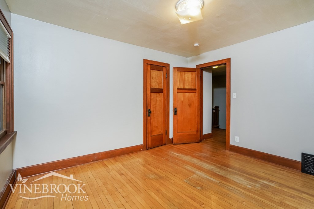 the living room of a house with wood floors and white walls