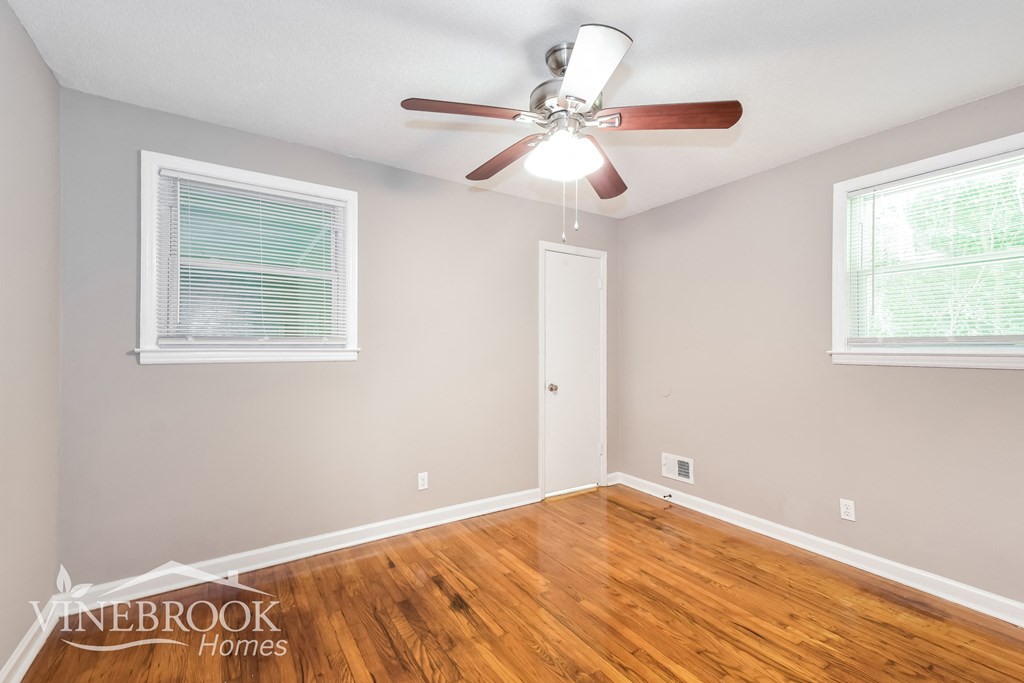 a living room with wood floors and a ceiling fan