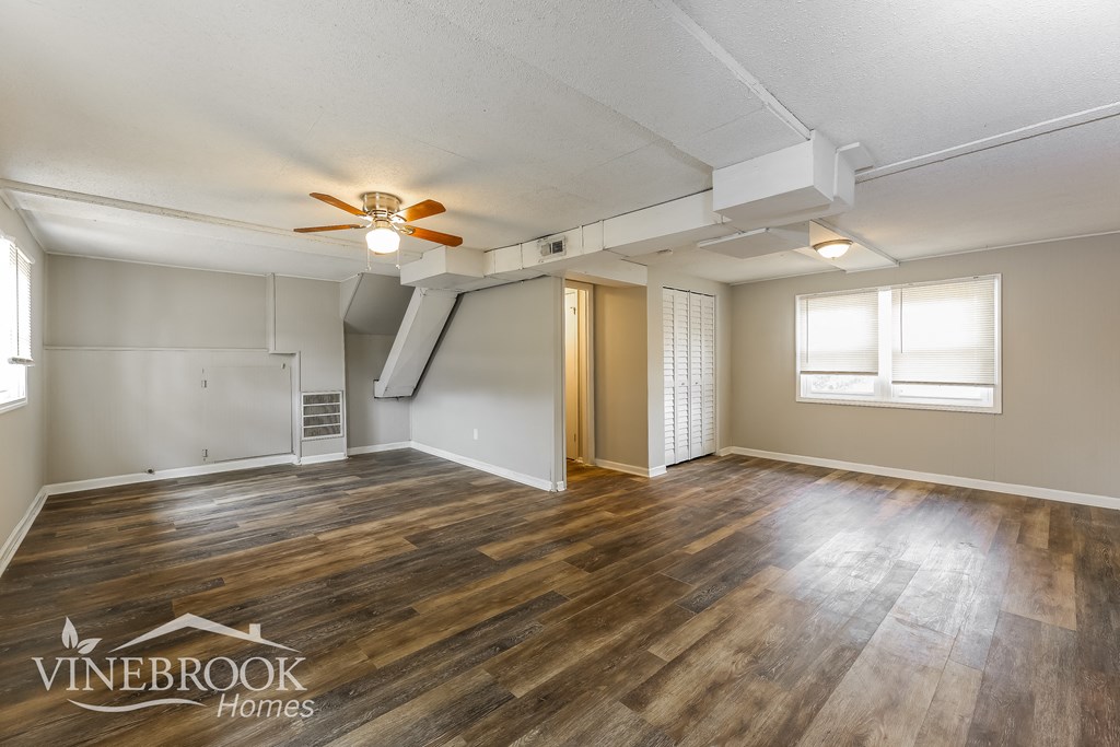 the living room and dining room with hardwood flooring and a ceiling fan