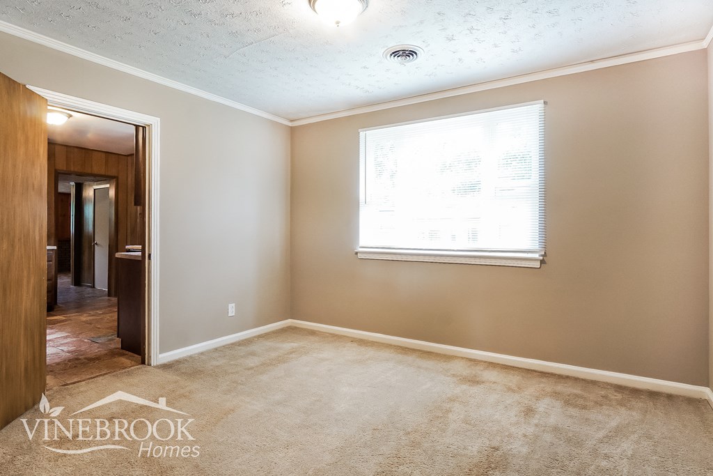 a bedroom with a carpeted floor and a window