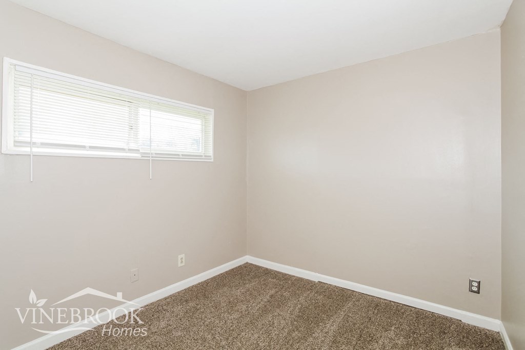 the living room of a home with a carpet and a window