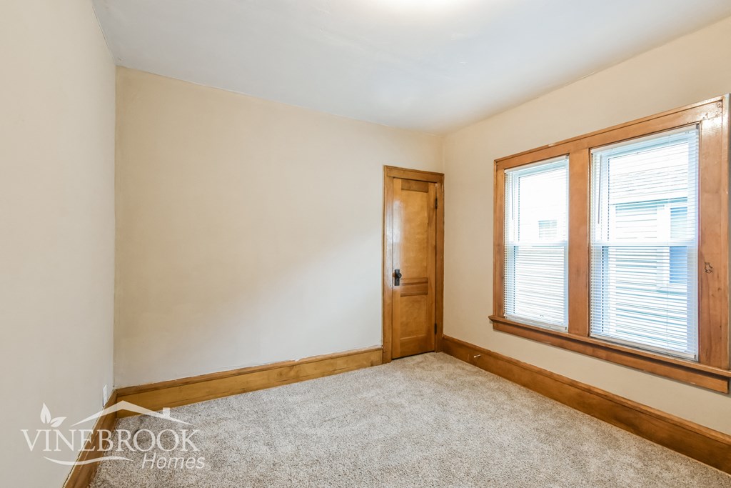 two windows and a door in a room with a carpet