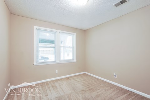 A room with a window and a car parked outside.