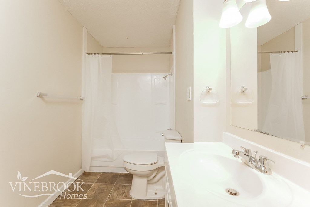a white bathroom with a sink and a toilet