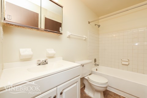 A white bathroom with a toilet, sink, and bathtub.