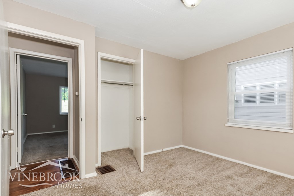 a bedroom with a closet and a door to a hallway