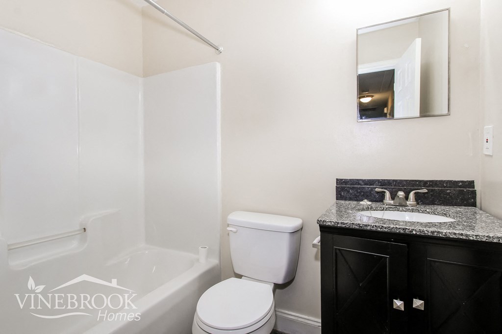 a white bathroom with a sink toilet and bath tub
