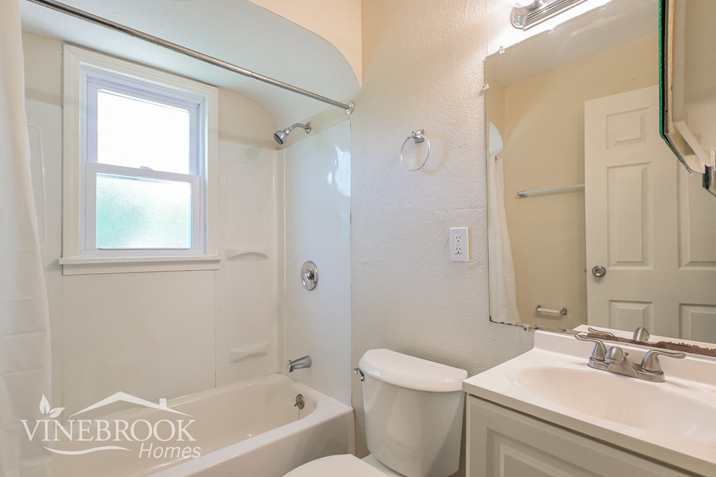 a bathroom with a toilet and a sink and a bath tub