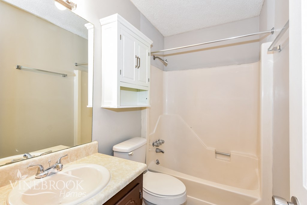 a bathroom with a toilet and a sink and a bath tub