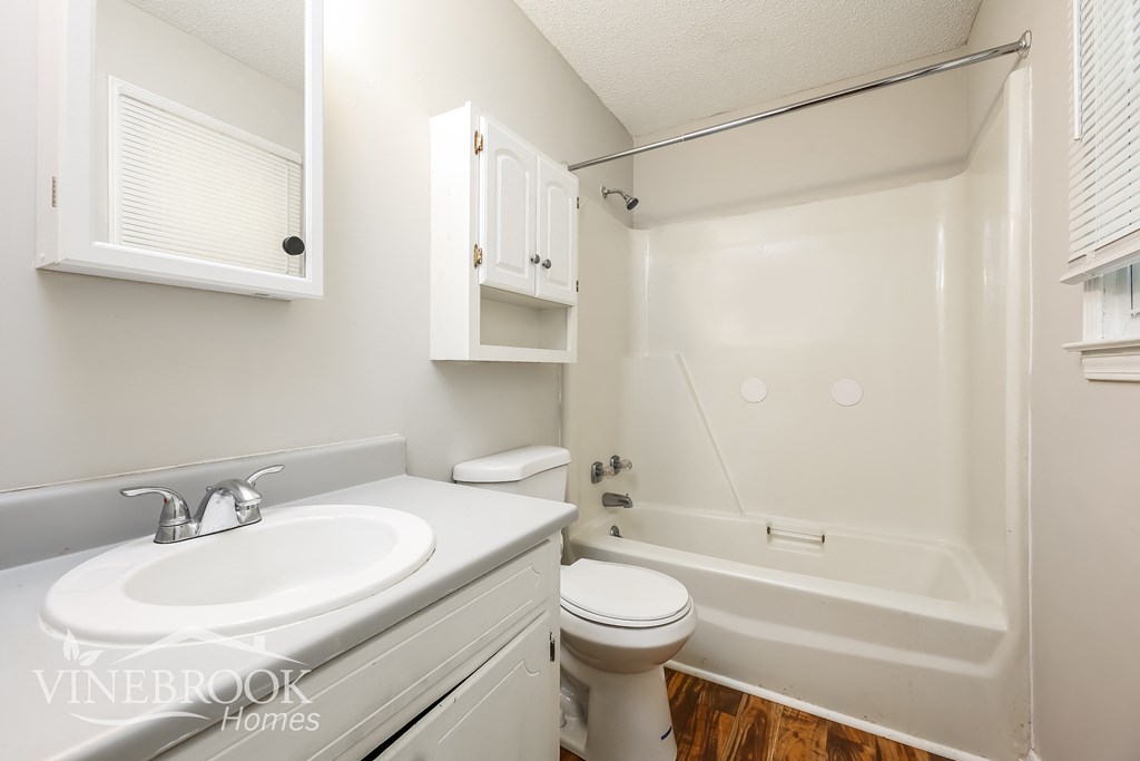 a white bathroom with a sink toilet and bath tub