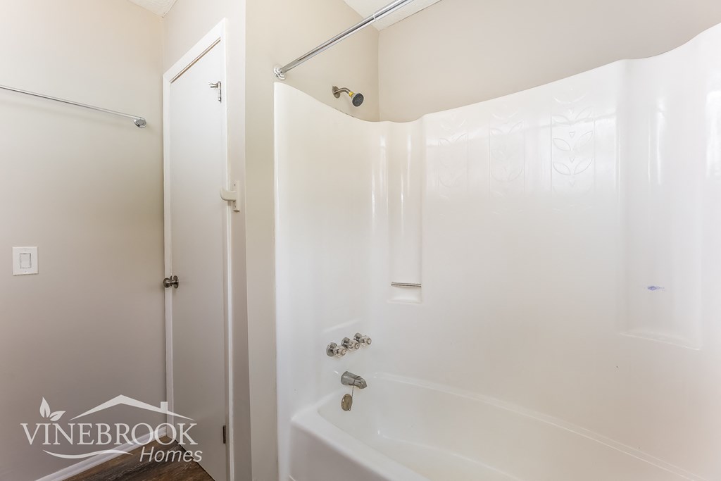 a white bathroom with a shower and a tub and a shower curtain