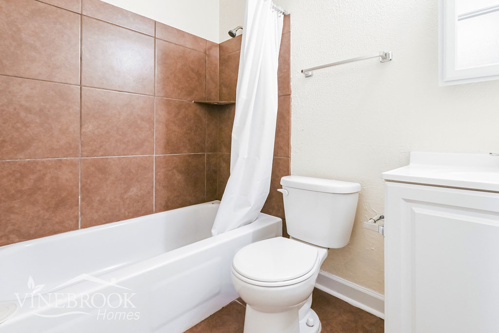 a bathroom with a toilet and a tub and a sink