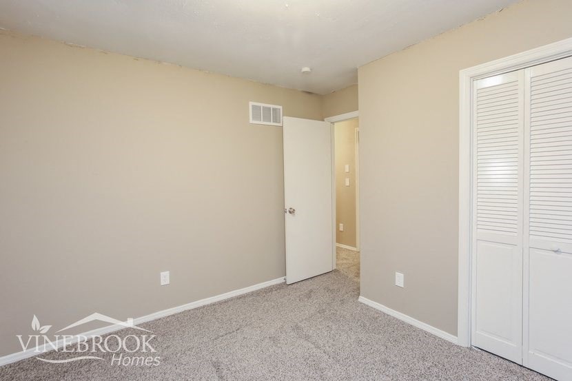 a bedroom with two closets and a door to a hallway