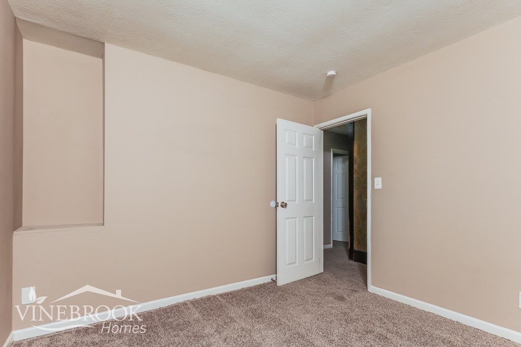 a bedroom with a closet and a door to a hallway