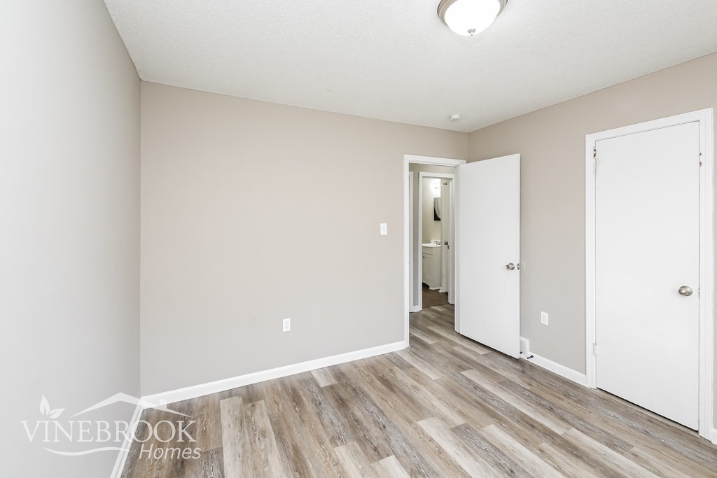 a renovated living room with wood floors and white walls
