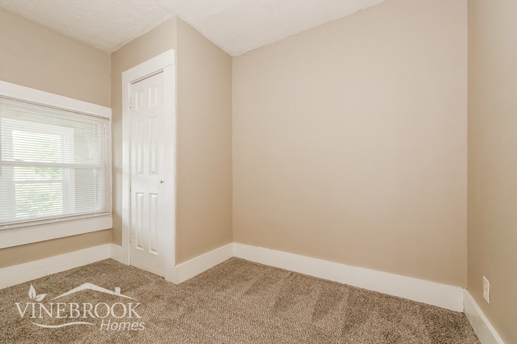 the living room of a home with carpet and a window