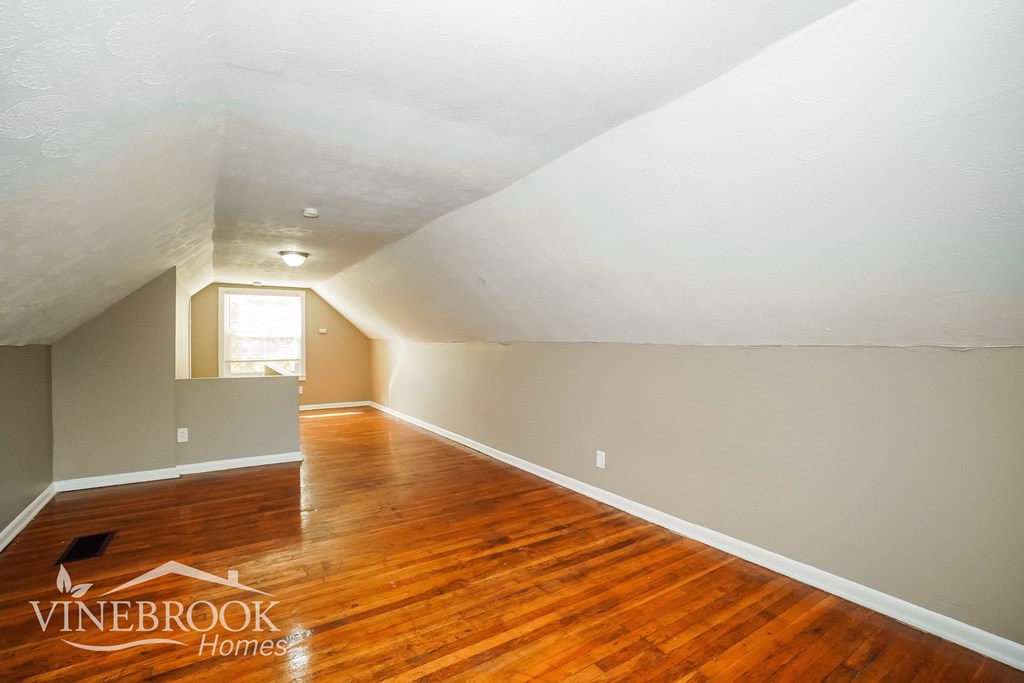 the living room of a home with a hardwood floor and grey walls