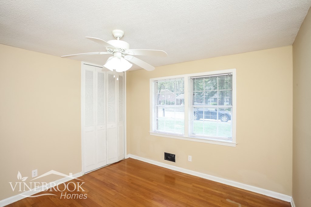 a bedroom with hardwood floors and a ceiling fan