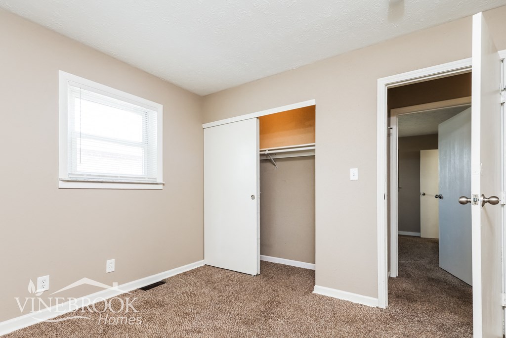 a bedroom with a closet and a mirrored closet door