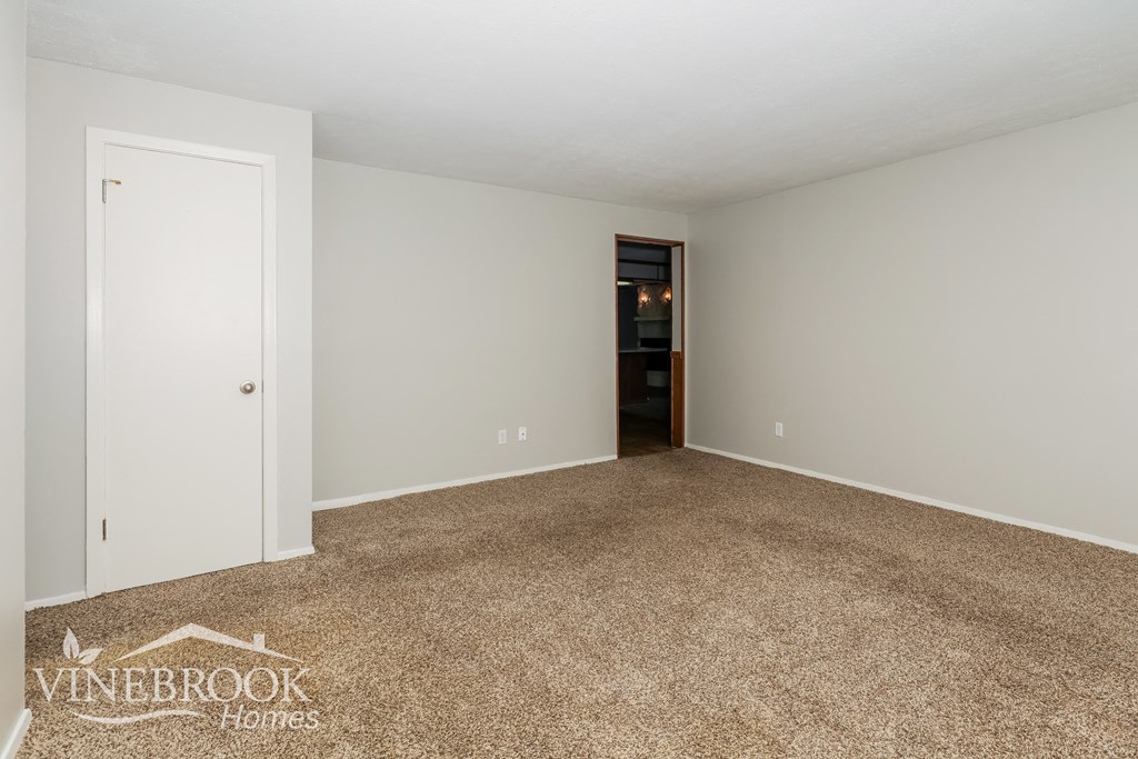 a master bedroom with carpet and a door to the bathroom