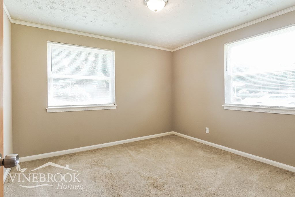 the living room of an empty home with two windows