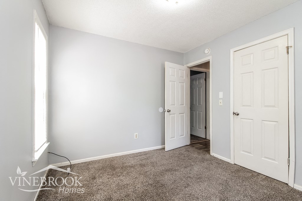 a bedroom with a carpeted floor and white doors