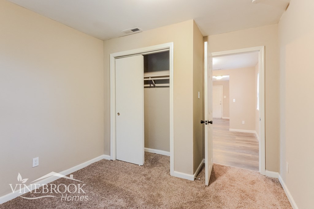 a bedroom with a closet and a hallway with a door to a closet
