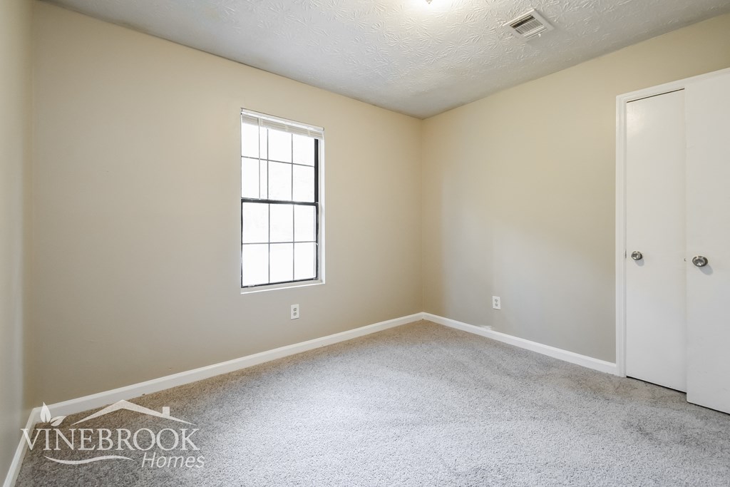 the living room of a home with carpet and a window
