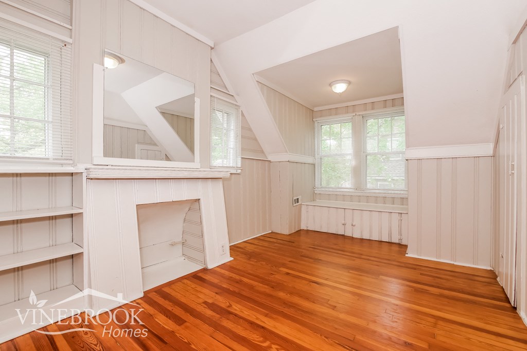 a living room with a hard wood floor and a fireplace