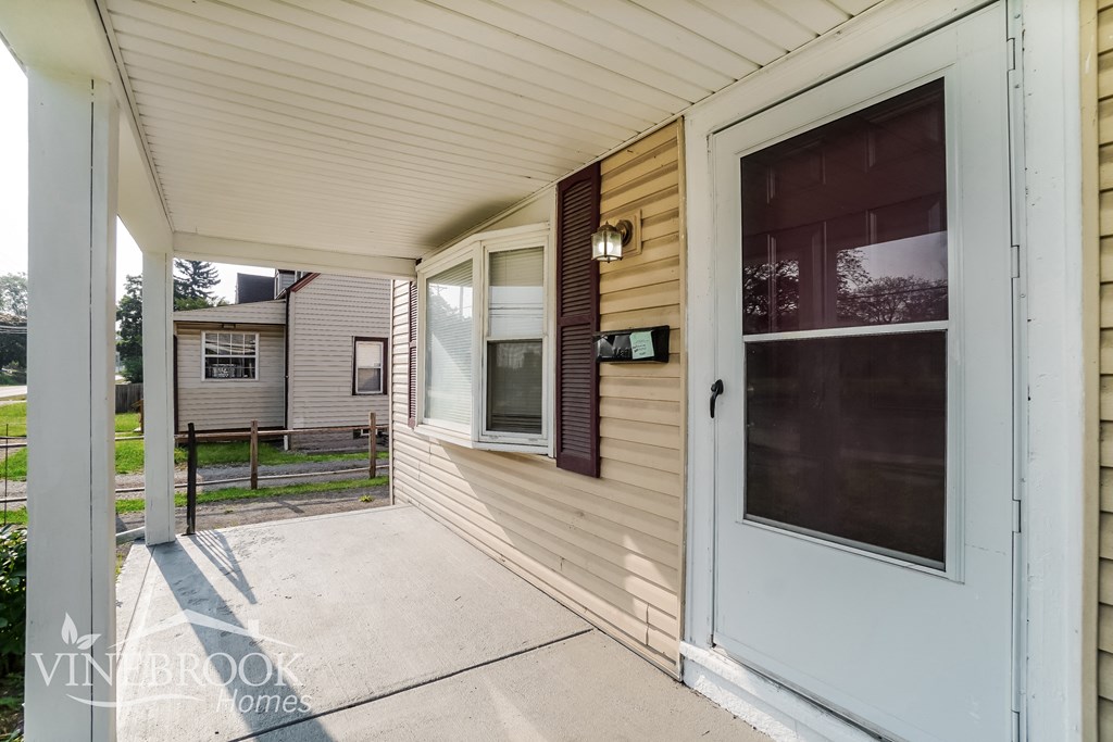 a blue front door of a home with a porch
