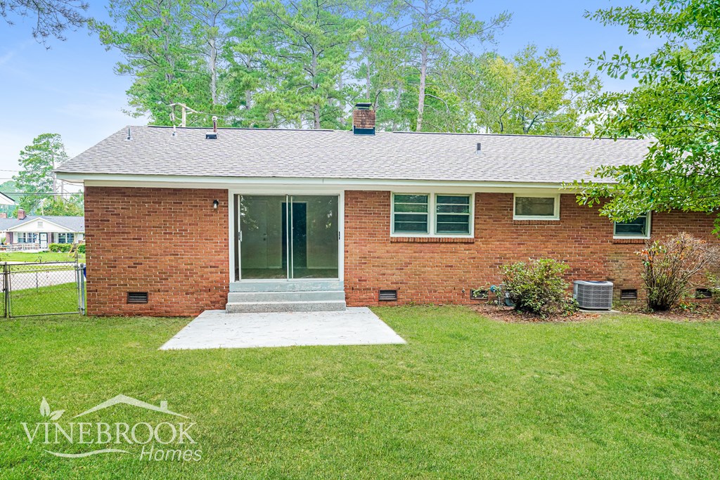 A house with a brick facade and a white door is for sale.