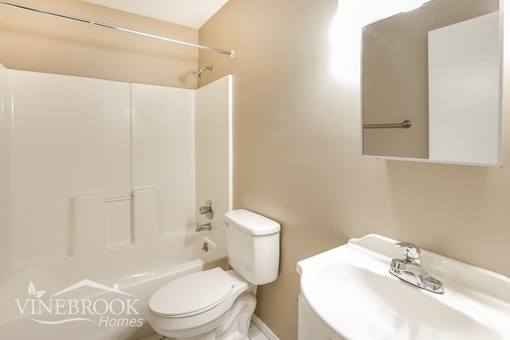 a white bathroom with a toilet and a sink
