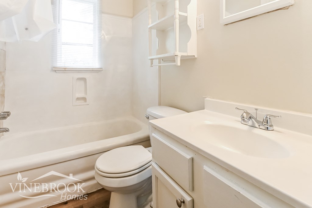 a white bathroom with a sink toilet and bath tub