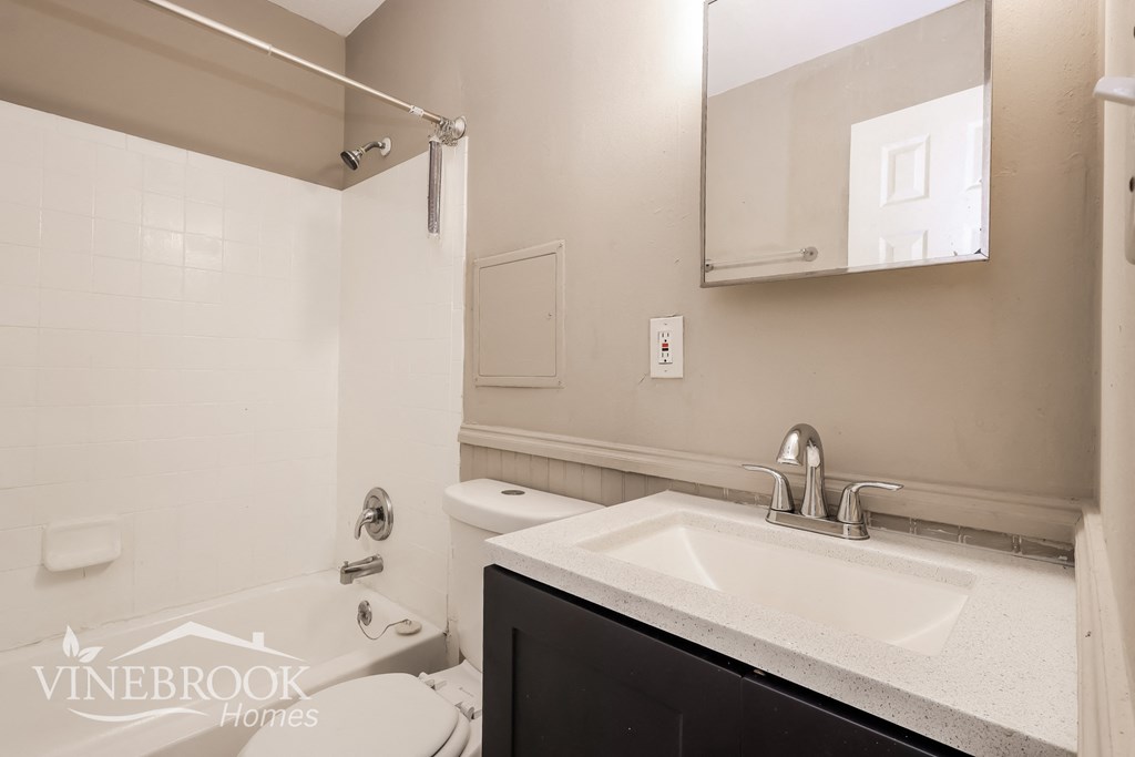 a white bathroom with a sink and a toilet and a tub