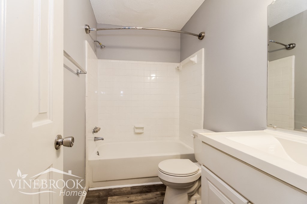 a white bathroom with a tub and a toilet and a sink